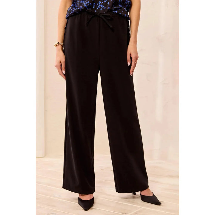 Model wearing the Tribal black flowy wide-leg pull-on pants with drawcord.