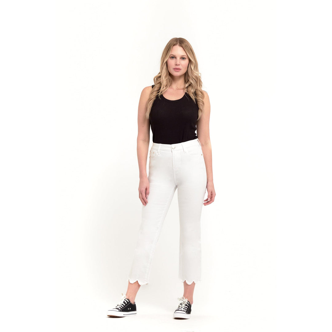 White high-waisted cropped straight-leg jeans by 1822 Denim showcasing a unique scalloped raw-style hemline.